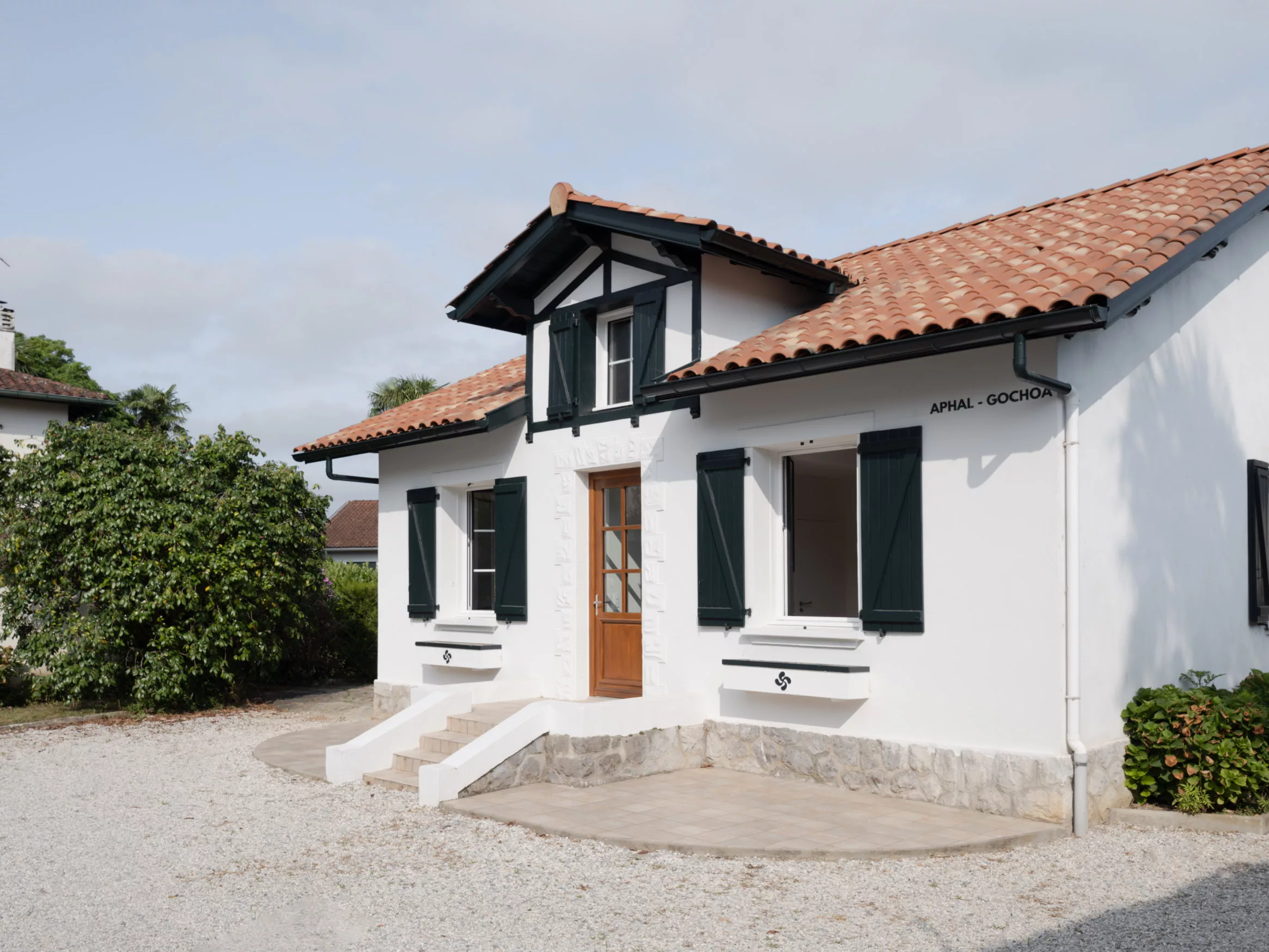 Façade d'entrée avec perron, auvent de tuiles et nom de la maison Aphal-Gochoa