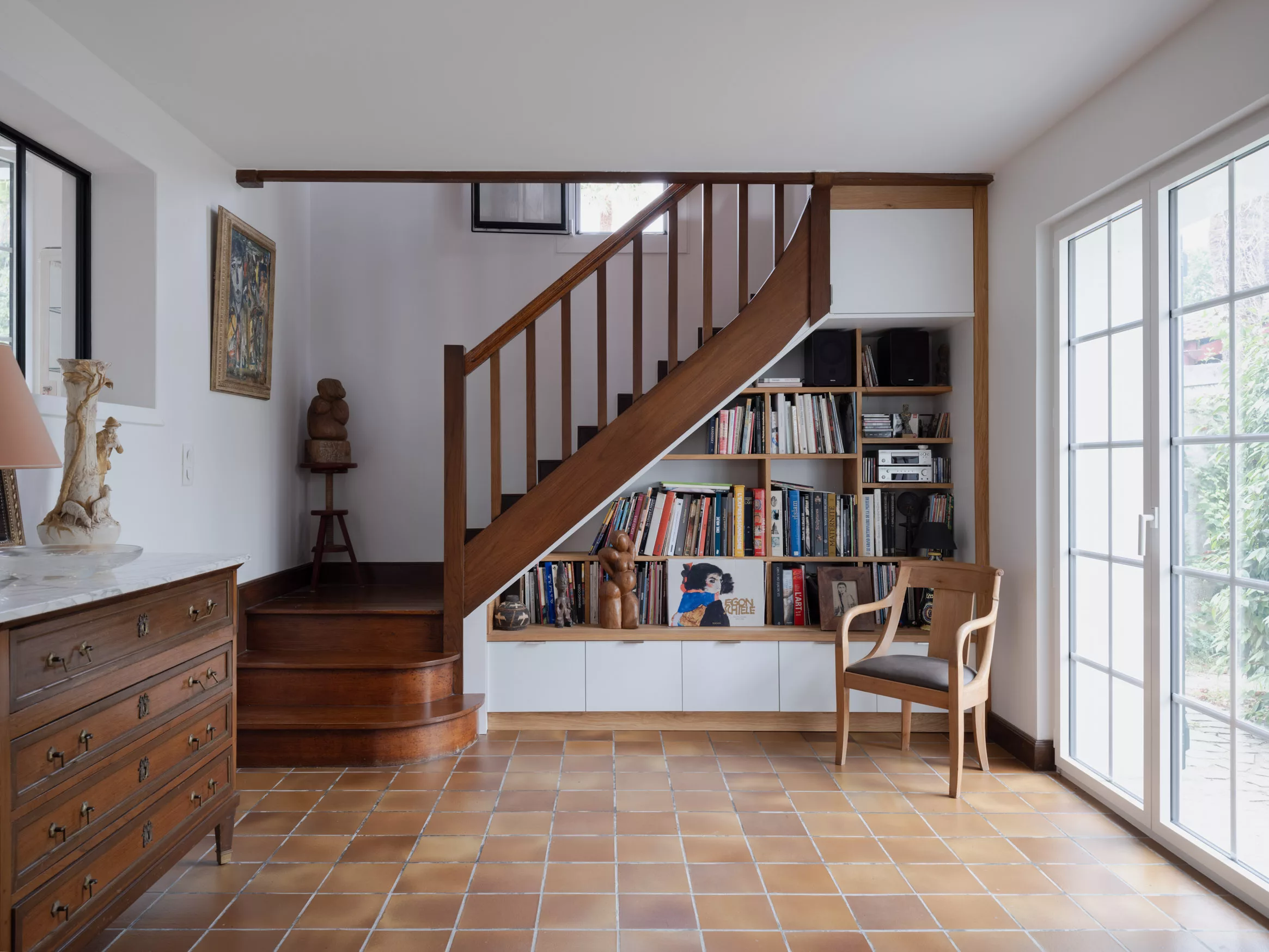Escalier en bois et sol en tomettes d'origine conservés, bibliothèque sur mesure aménagée sous l'escalier
